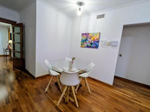 a dining room with a glass table and white chairs at Apartamento Córdoba Center in Córdoba