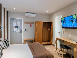 a bedroom with a bed and a desk and a television at H33 Hôtel in Nice +79 photos