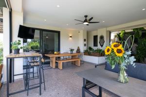 a living room with tables and a vase of sunflowers at Private Pool Villa by the Sea in Kalamata