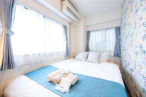 a small bedroom with a bed with towels on it at 新宿駅まで12分渋谷駅まで22分最大8名様宿泊可能4ベッドルーム in Ogikubo