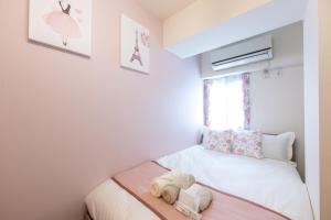 a small bedroom with a bed with towels on it at 新宿駅まで12分渋谷駅まで22分最大8名様宿泊可能4ベッドルーム in Ogikubo