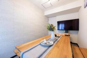 a living room with a table and a tv at 新宿駅まで12分渋谷駅まで22分最大8名様宿泊可能4ベッドルーム in Ogikubo