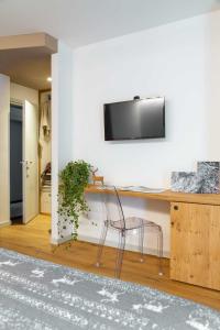 a desk with a chair and a television on a wall at Meublè La Betulla in Chiesa in Valmalenco +56 photos