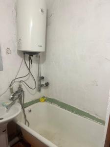 a bathroom with a sink and a bath tub at Квартира у Асели in Karakol +18 photos
