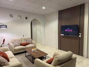 a waiting room with two couches and a tv at شقق أريز ستاي in Al Hada