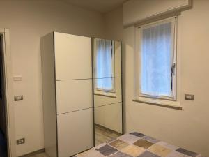 a bedroom with a refrigerator and a window at Giuly House in Arco
