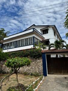 a white house with a gate and a garage at Blue House Watamu in Watamu