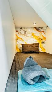 a bed in a room with a painting on the wall at Rc Guest House in Phi Phi Islands