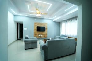 a living room with a couch and chairs and a tv at Nandan Enclave 2BHK & 3BHK Family Apartments in Mysore Parking & Kitchen in Mysore