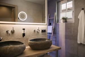 a bathroom with a large stone sink and a mirror at BRUGGER ApartHotel in Mayrhofen +55 photos