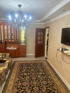 a living room with a couch and a chandelier at Квартира у Асели in Karakol