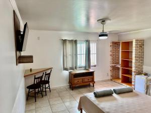 a room with a table and a desk in a room at Pousada Convés das Ondas in Penha