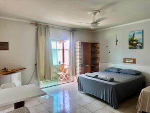 a bedroom with a bed and a balcony at Pousada Convés das Ondas in Penha