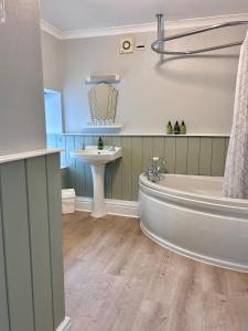 a bathroom with a tub and a sink at The Beacons Guest House in Brecon +21 photos