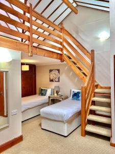 a bedroom with two beds and a staircase in a house at The Beacons Guest House in Brecon