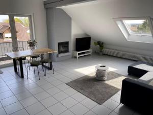 a living room with a table and a tv at Loft mit Kaminofen - Karlsdorf in Karlsdorf-Neuthard