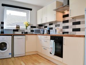 a kitchen with black and white tiles on the wall at Harbour View in Oban