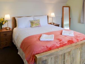 a bedroom with a large bed with two towels on it at Harbour View in Oban