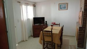 a dining room with a table and a television at Abuela Chiquita in Ramallo