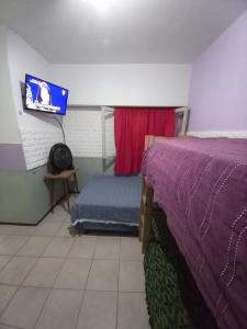 a bedroom with a bed and a tv on the wall at Casona Sol in Mar del Plata