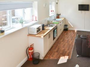 a kitchen with a sink and a stove top oven at Swan's Nest - Uk43545 in Belford