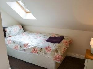 a small bedroom with a bed with flowers on it at Swan's Nest - Uk43545 in Belford +4 photos