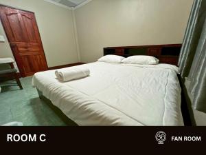 a bedroom with a large bed with white sheets and pillows at Huean Him Pan Homestay เฮือนฮิมปานโฮมสเตย์ in Ban Mae Pan