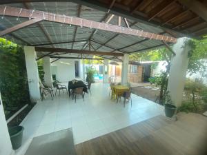 an outdoor patio with chairs and tables and awning at Pousada - Aconchego do Sol in João Pessoa
