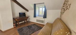 a living room with a couch and a desk at Oustal de Piarelle in Saint-Jean-du-Bruel