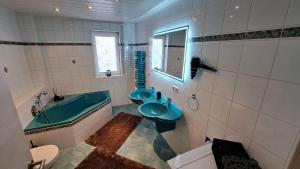 a bathroom with two sinks and a bath tub at Appartment am Lämmerberg in Pößneck +12 photos