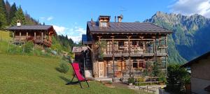 a house on a hill with mountains in the background at Tabià Fregona, Chalet Alpino con vista e stile tradizionale in Fregona