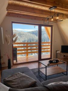 a living room with a couch and a large window at The Tara Concept in Šljivovica