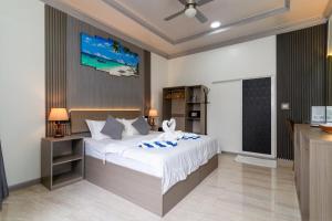 a bedroom with a large bed with a tv on the wall at Hidden Tide Villa in Ukulhas