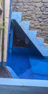 a pool of blue water next to a building at Bird Park Villa Ella in Ella