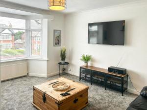 a living room with a coffee table and a flat screen tv at Highcross in Poulton le Fylde