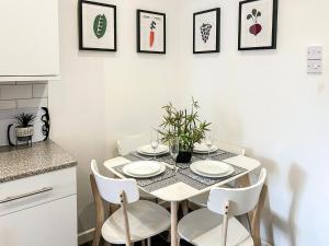a white dining room table with white plates and chairs at Highcross in Poulton le Fylde