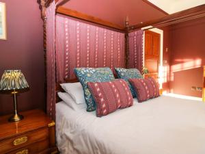 a bedroom with a canopy bed with red and blue pillows at Braeriach - Mar Lodge Estate in Ballater