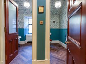 a hallway with a bathroom with blue walls and a door at Braeriach - Mar Lodge Estate in Ballater +46 photos