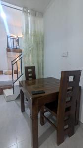a wooden table and chairs in a room at Bird Park Villa Ella in Ella