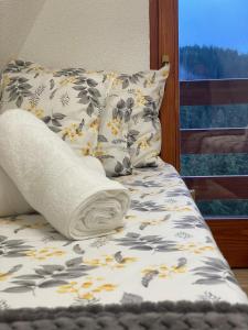 a bed with a pillow and a towel on it at The Tara Concept in Šljivovica