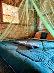 a bed in a tent with a net at Kohmook Money RUEAN PHAI in Trang