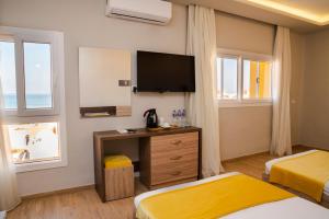 a hotel room with two beds and a flat screen tv at Al Dora Boutique Hotel in Hurghada