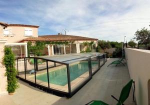 a house with a swimming pool on a patio at Le Clos des Galets in Meynes