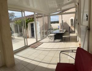 a screened in porch with a table and chairs at Le Clos des Galets in Meynes