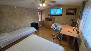 a room with two beds and a desk and a tv at ApartHotel SAVAS 4 Private house with parking in Kaunas