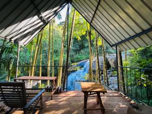 a screened in porch with a view of a river at River Splendour Home Stay in Ella