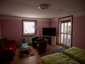 a living room with a couch and a television at Ferienwohnung Wieck Greifswald in Wieck