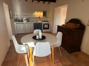 a kitchen with a white table and white chairs at Luce su Civita in Lubriano +11 photos
