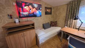a room with a couch and a tv on the wall at ApartHotel SAVAS 4 Private house with parking in Kaunas +27 photos