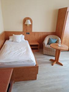 a bedroom with a bed and a table and a chair at Hotel Flora in Bad Harzburg
